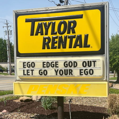 Sign for Taylor Rental with yellow background reads 